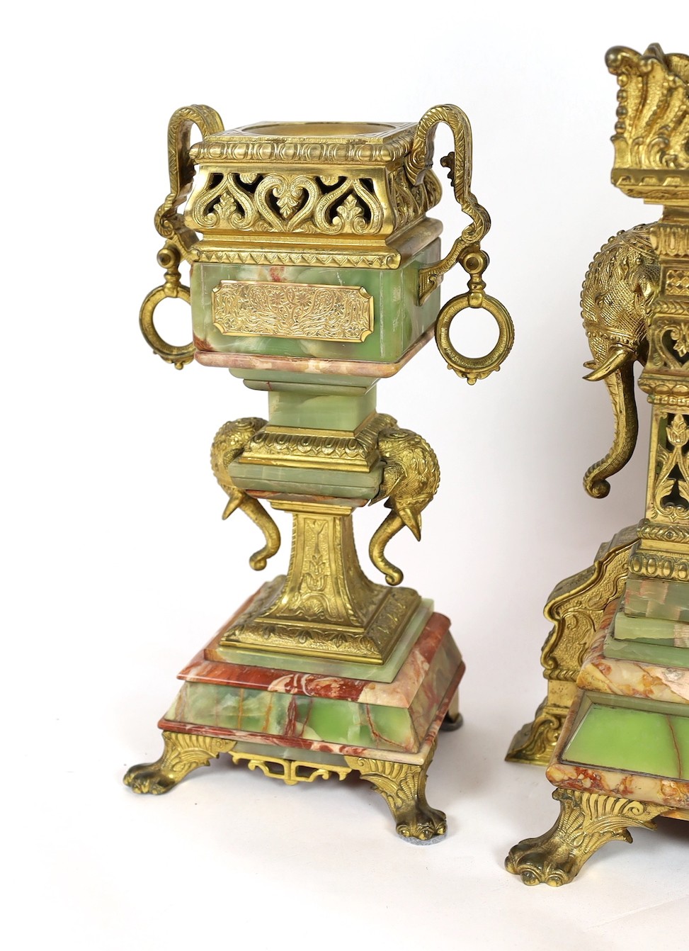 A late 19th century French ormolu mounted marble and green onyx clock garniture, of Indian inspiration, clock 34cm wide, 63cm high, side vases 36cm high